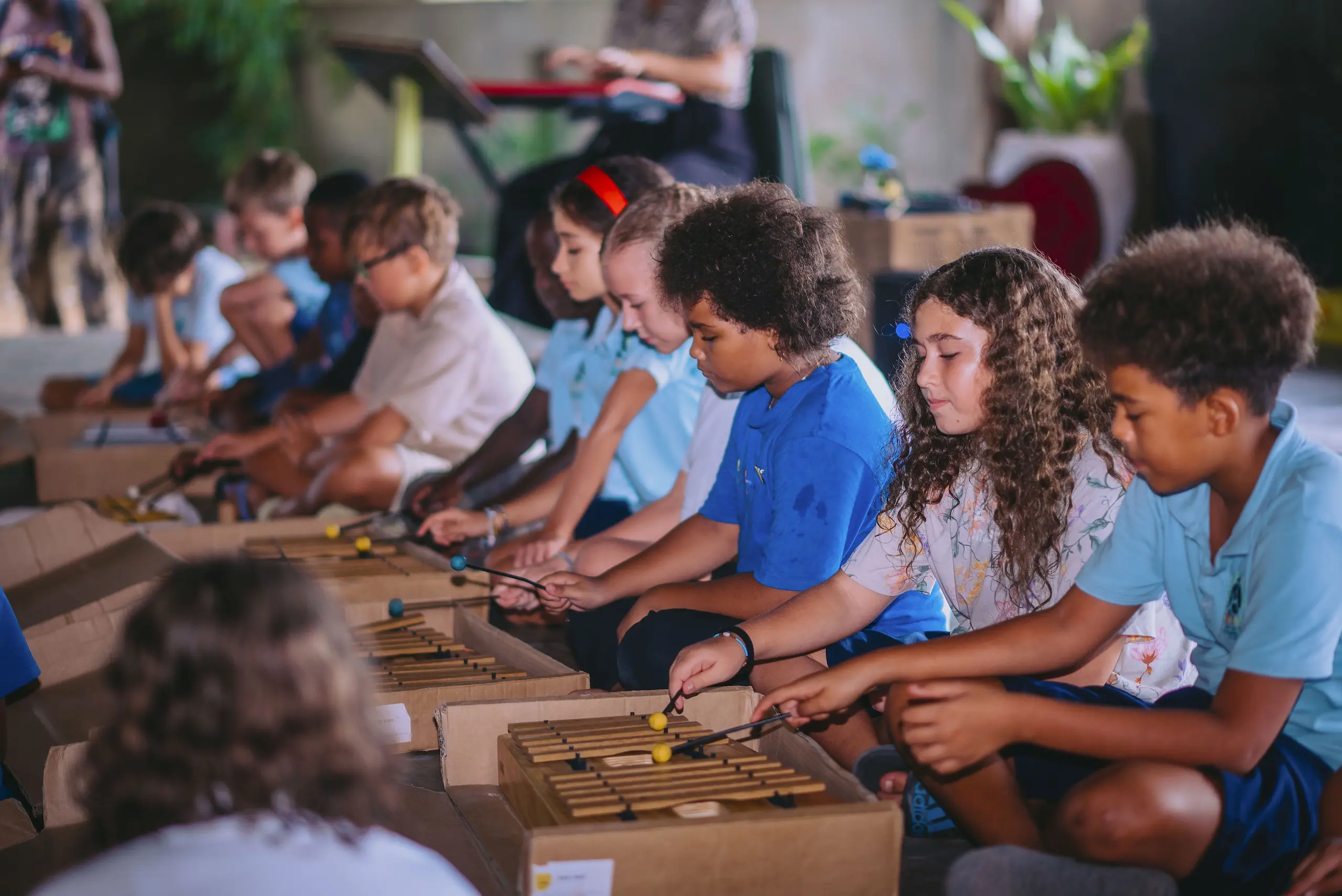 South East Coast International School Zanzibar pupils sat on the floor playing xylophones during a music lesson